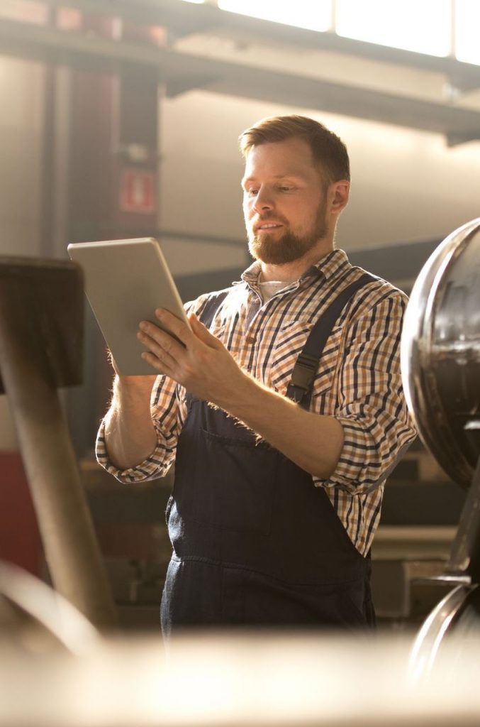 Mann in der Firma mit einem I-Pad in der Hand